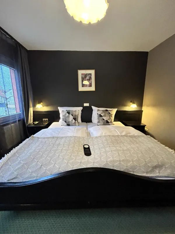 Doppelzimmer mit dunkler Akzentwand und Wandleuchten