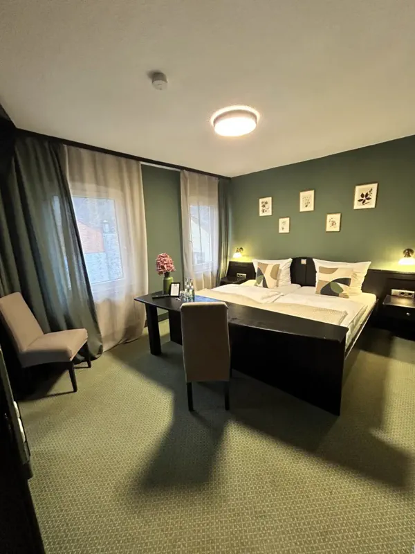 Doppelzimmer in Salbeigrün mit botanischen Drucken und Schreibtisch