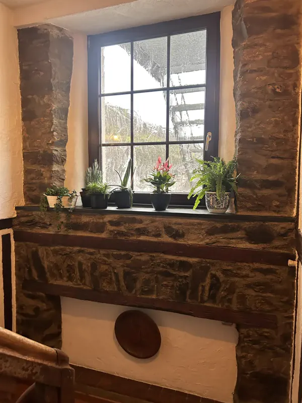 Rustikales Sprossenfenster mit Natursteinwand im Gastraum